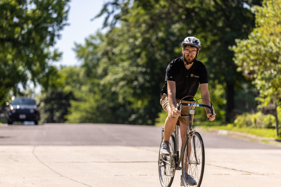 Justin Krohn riding around Columbia on his bike to track the location of invasive pear trees.