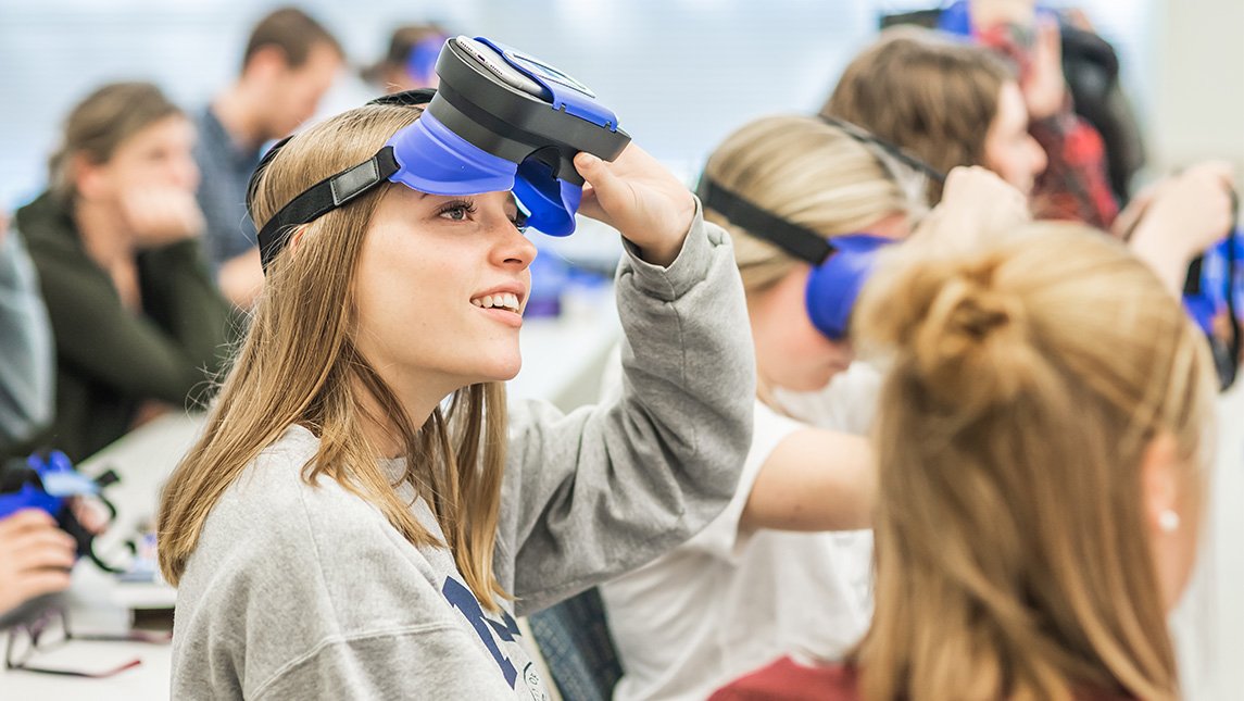 Student takes off a virtual reality headset after trying it out.