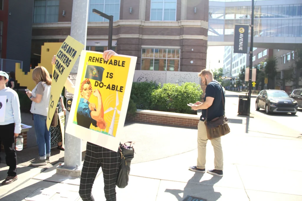 People gather in the Bakery Square area of Larimer Thursday, Sept. 11, to protest the nearby AI Horizons Summit. (Photo by Eric Jankiewicz/Pittsburgh’s Public Source)